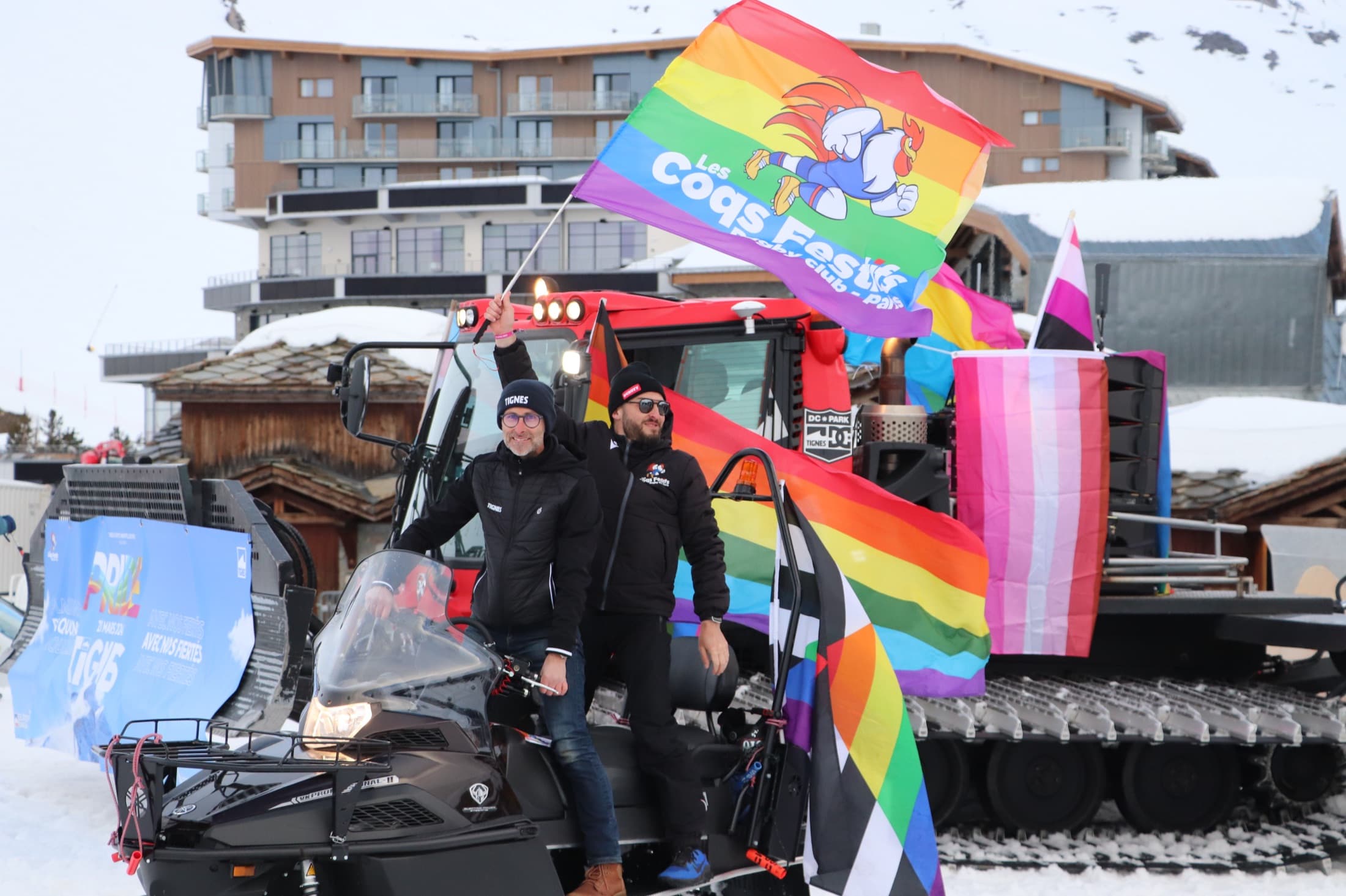 Les Coqs Festifs sur une dameuse avec leur drapeau à l’European Snow Pride de Tignes