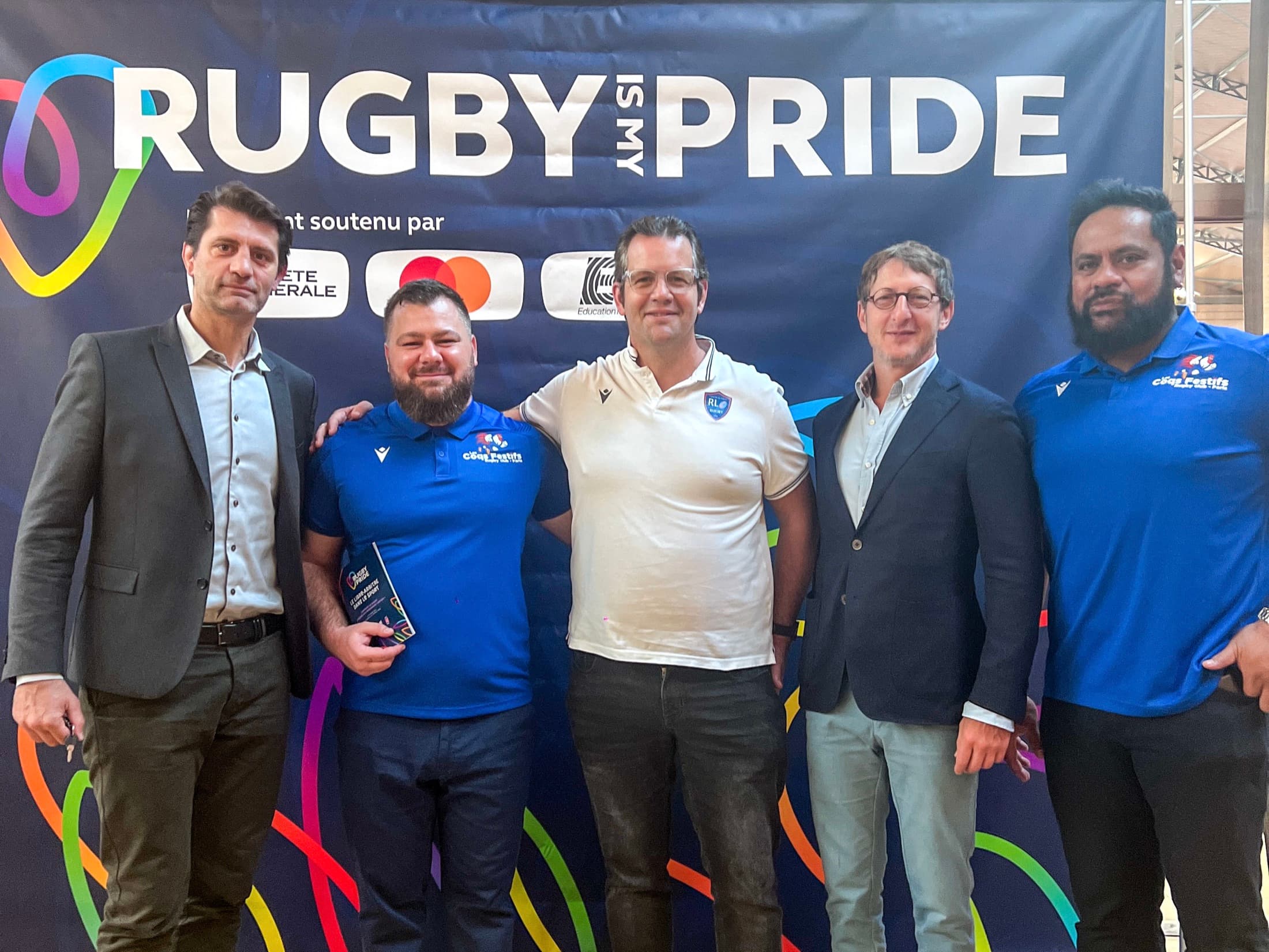 Les Coqs Festifs devant le logo Rugby Is My Pride, entourés de leurs partenaires