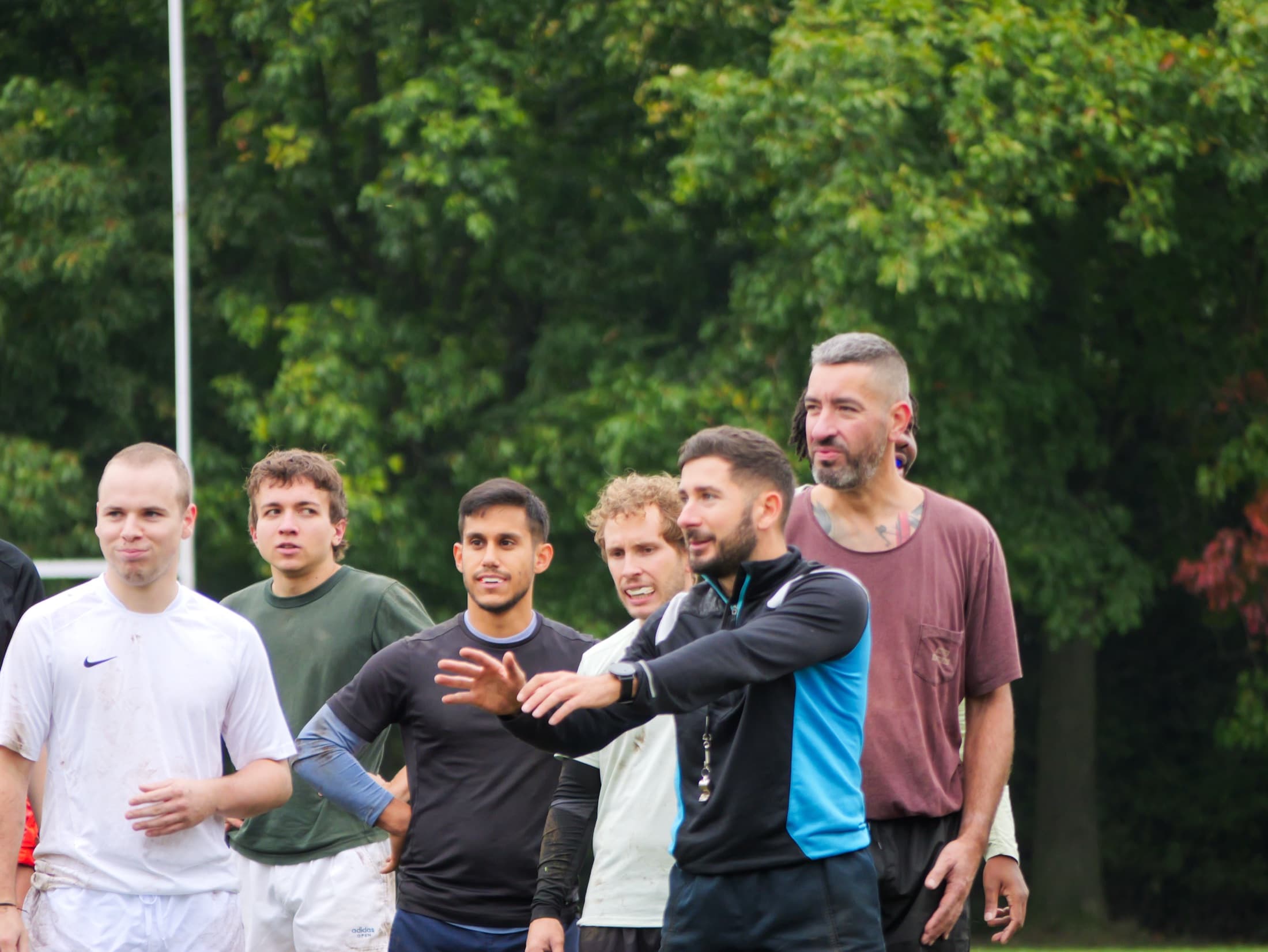 Joueurs et coach des Coqs Festifs en discussion sur le terrain