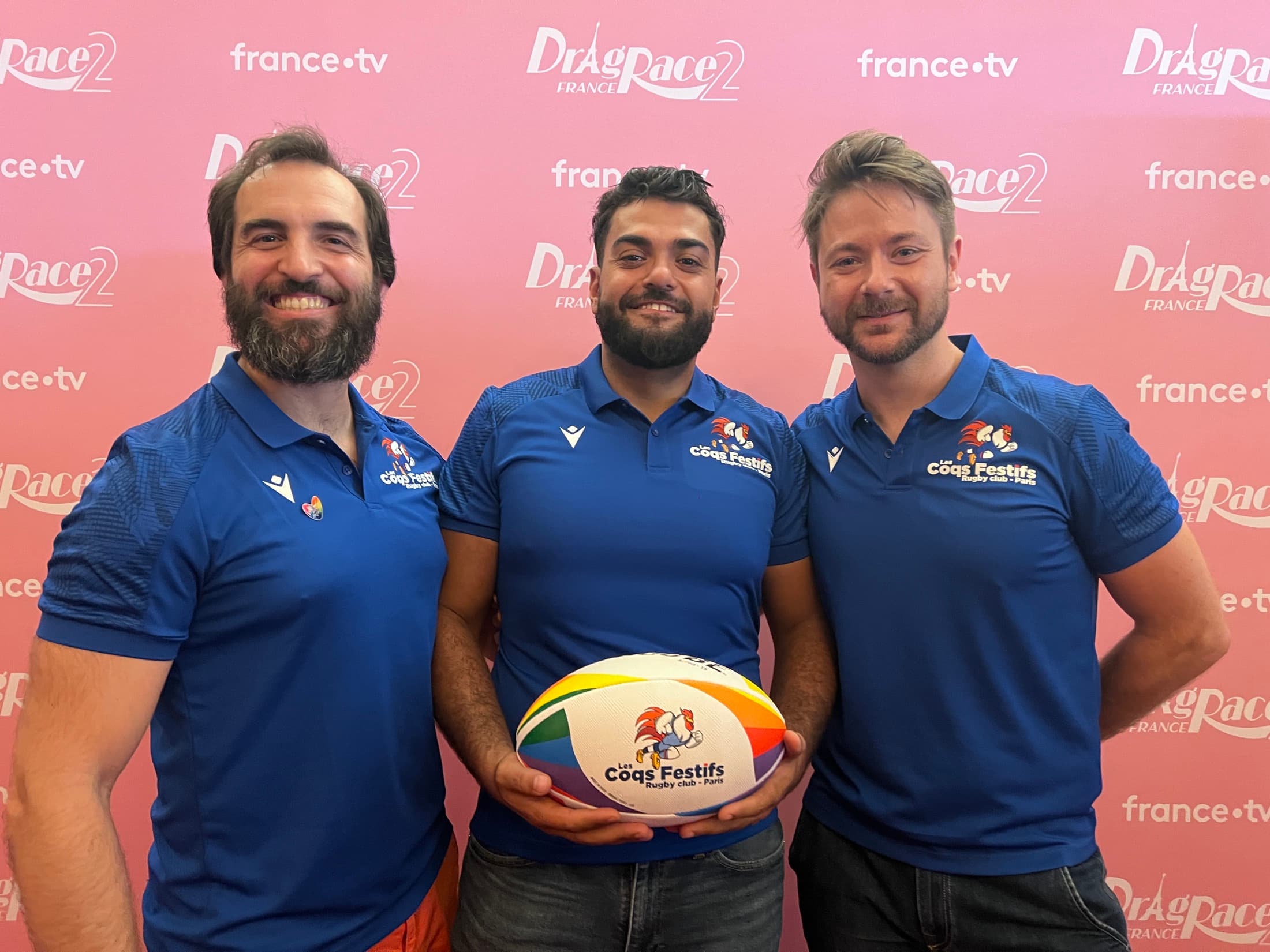Trois joueurs des Coqs Festifs avec un ballon devant le photocall de Drag Race France